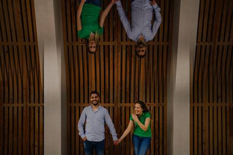 Namorados de mãos dadas sorriem no Jardim Botâncio'