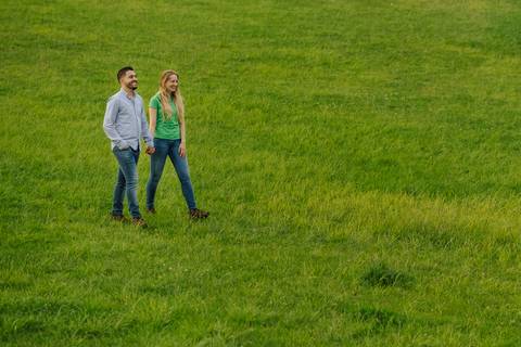 Bonito casal de namorados a passear de mão dada, no parque verde da cidade de Coimbra'