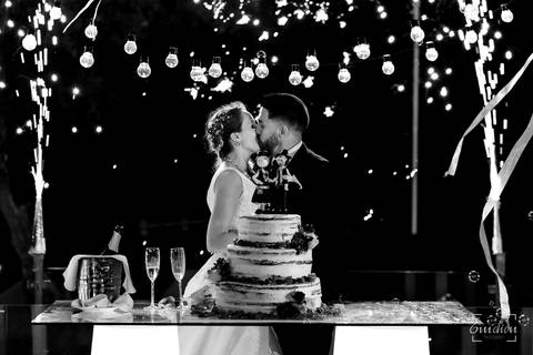 Noivos beijam-se durante o corte do bolo na Quinta das Janelas.'