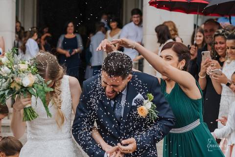 Convidada enche o noivo com muito arroz.'