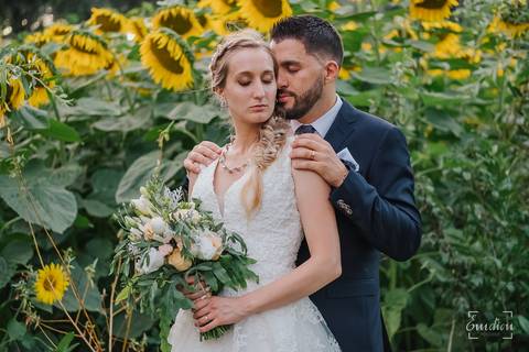 Noivos abraçam-se junto a campo de girassóis, na Quinta das Janelas.'