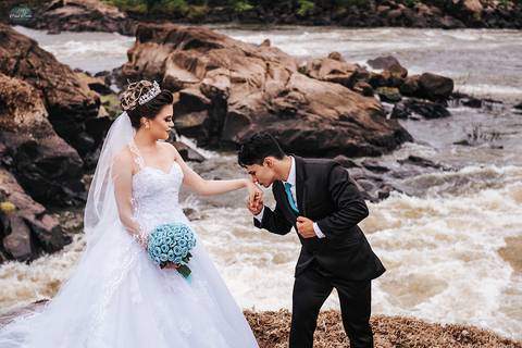 Noivo beija a mão da noiva na cachoeira '