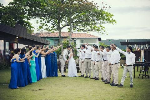 trajes de madrinhas de casamento tons azul padrinhos em tom bege praia por do sol bombinhas'
