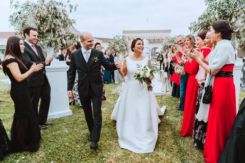 salida de esposos felicidad y aplausos de amigos e invitados novios felices con estilo boda al aire libre en puericultorio de lima '
