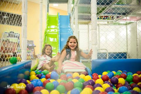 aniversariante escorregando na piscina de bolinhas  com a amiga no fim da festa'