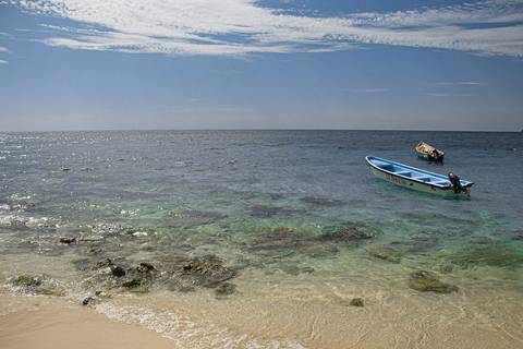 mar com barco em dia de sol'