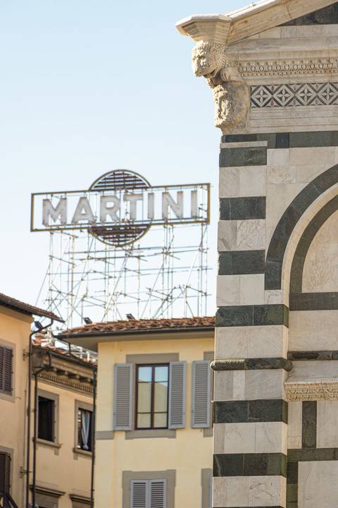 Letreiro Martini com edifício em Florença na Itália de dia'