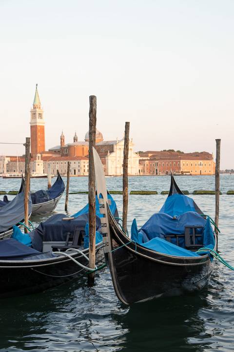Detalhe das gondolas ao entardecer com vista para o mar em Veneza'
