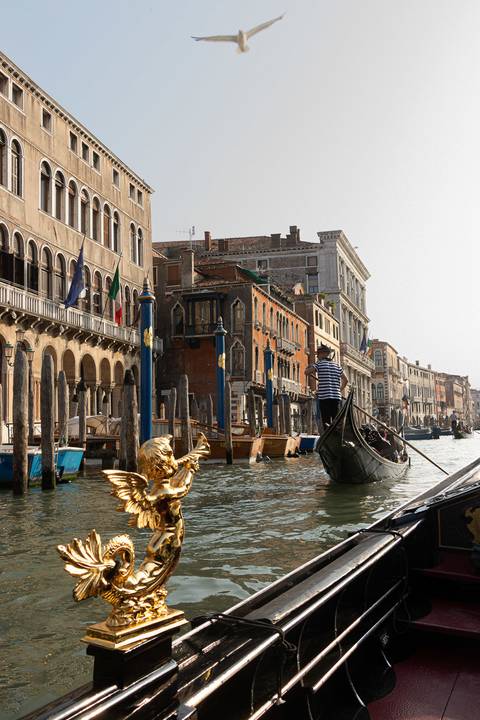 Gondola com ornamento de anjo e gondoleiro em Veneza'