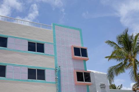 Edifício colorido com coqueiro no Art Deco District em Miami'