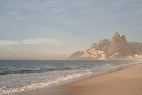 Praia de Ipanema ao amanhecer com o Morro Dois Irmãos de fundo'