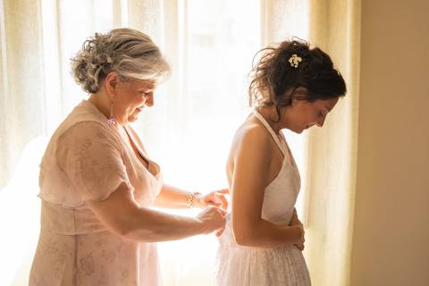 mãe a apertar o vestido da noiva - '