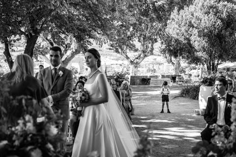 fotografia a preto e branco de noivos no altar e menino das alianças atrás - casamento na Quinta da Pacheca'