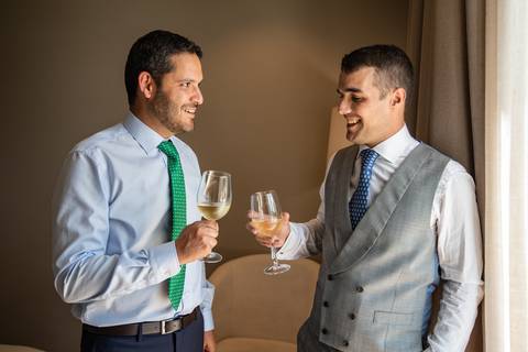 fotografia de noivo a brindar com o padrinho de casamento'