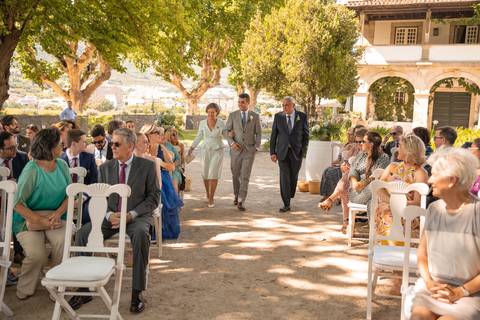 fotografia de casamento na Quinta da Pacheca - noivo a caminhar até ao altar no meio dos pais'