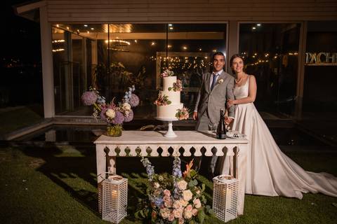 fotografia de noivos e o bolo de casamento'