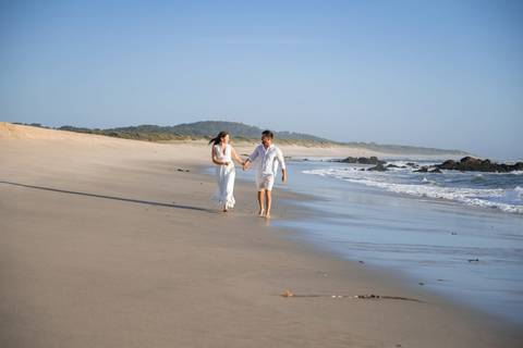 casal de noivos a correr - fotografia de pré-wedding na praia'