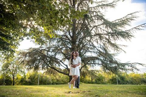 sessão fotográfica na natureza - casal abraçado em frente a uma árvore'