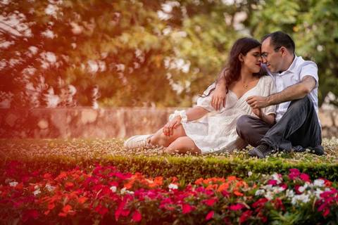 casal sentado na relva a olhar um para o outro'