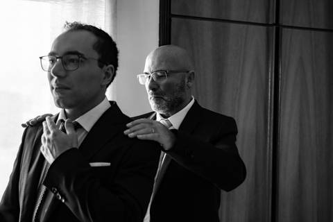 Pai a ajeitar o casaco do noivo - fotografia de casamento'