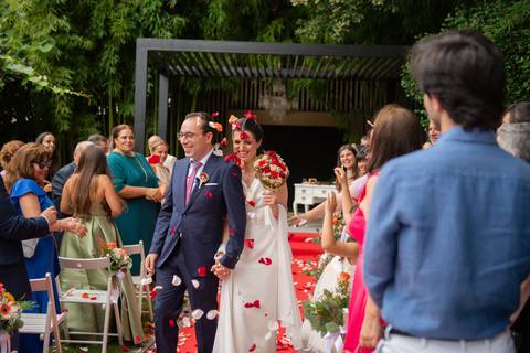 noivos a caminhar de mão dada enquanto são atiradas pétalas - fotografia de casamento no Porto'