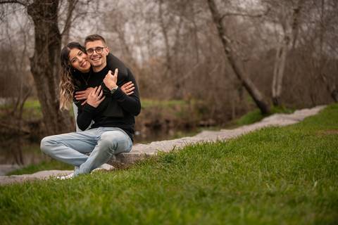 casal abraçado sentado no jardim - sessão fotográfica de dia dos namorados em Ermesinde'