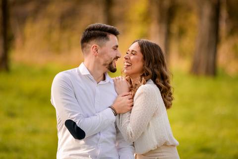 casal abraçado a rir-se - fotografia no jardim'