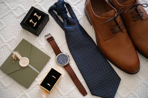 fotografia dos acessórios que o noivo vai usar no casamento - sapatos, relógio, gravata, alianças, botões de punho'