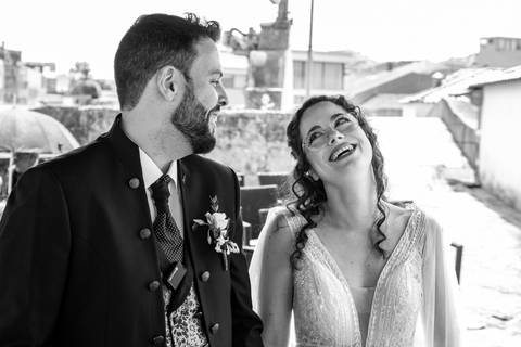 retrato de noivos a sorrir a olhar um para o outro - fotografia de casamento a preto e branco'