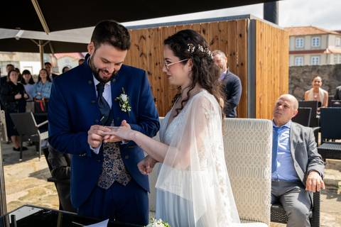 fotografia de casamento do casal a trocar alianças'