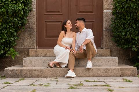 casal sentado em degraus a olhar um para o outro - sessão fotográfica de pré wedding'