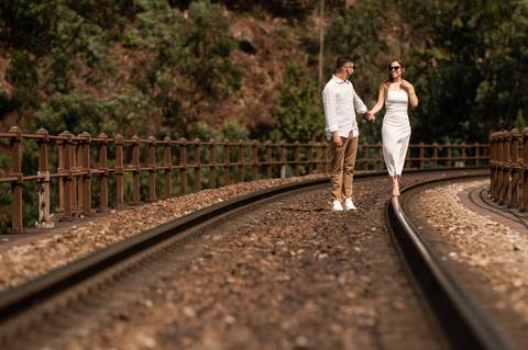 casal a caminhar de mão dada numa linha de comboio - sessão fotográfica de pré wedding'