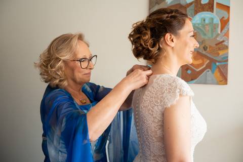 mãe a apertar o vestido da noiva - fotografia de casamento no Porto'
