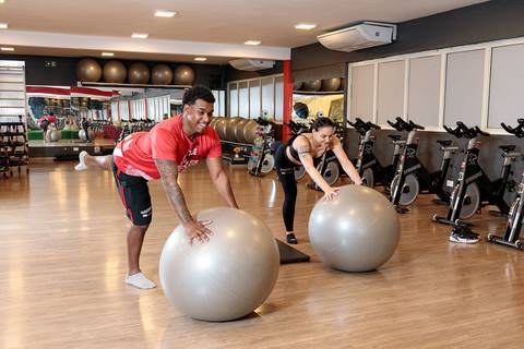 Treino funcional com bola suíça realizado por alunos na Academia Inova'