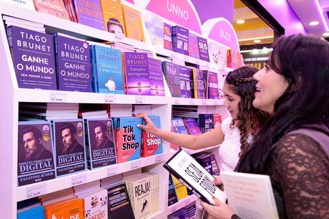 Leitores escolhendo livros no estande da Buzz Editora durante a Bienal'