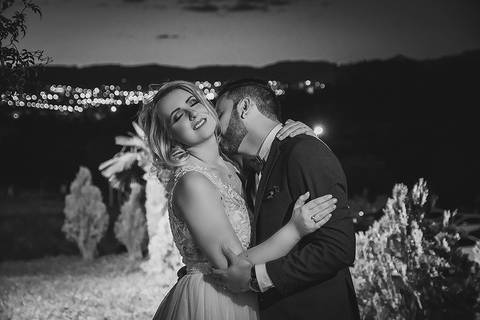 Casamento ao ar livre beijo dos noivos em foto em preto e branco'