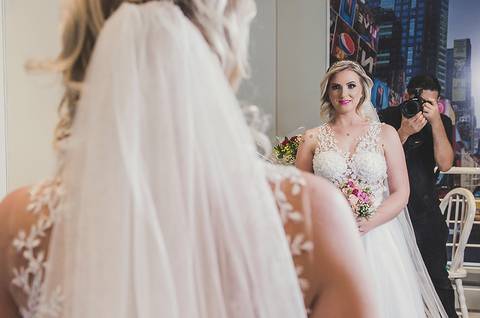 Making of da noiva de vestido em frente ao espelho com o fotógrafo'