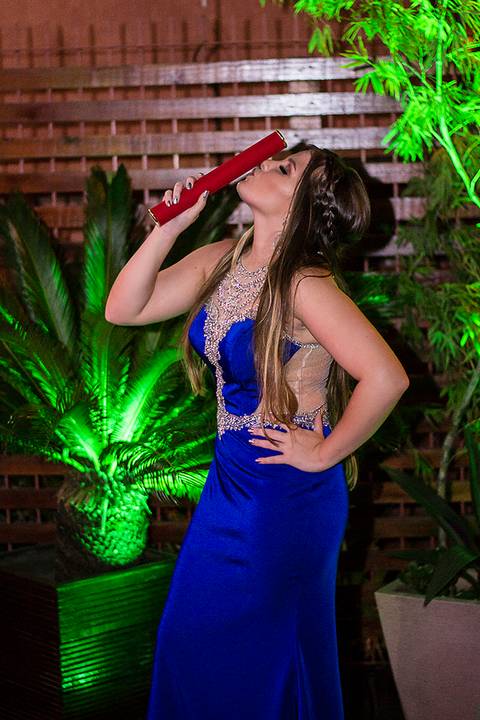 Formanda segurando o canudo diploma em sua festa de formatura'