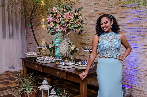 Formanda posando para fotos na mesa de doces'