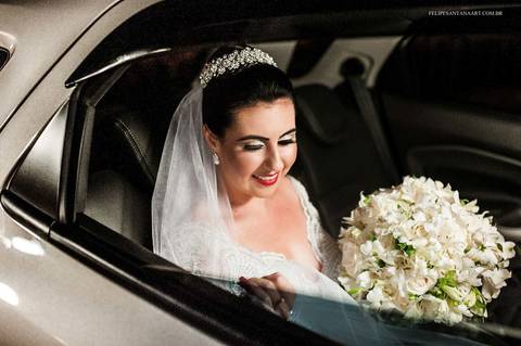 Noiva chegando de carro no casamento com buquê de flores branco, fotografia de casamento com sorriso da noiva'