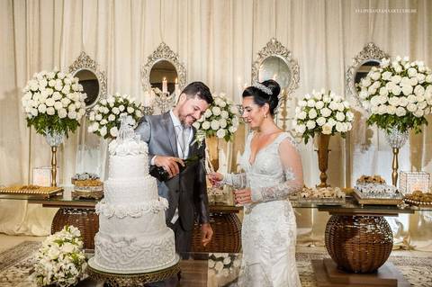 Fotografia dos noivos na recepção do casamento, foto de noivos lindos, foto de casamento atrás da mesa de doces, brinde na recepção do casamento'