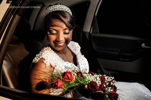 Noiva olhando para seu buquê no dia de seu casamento'