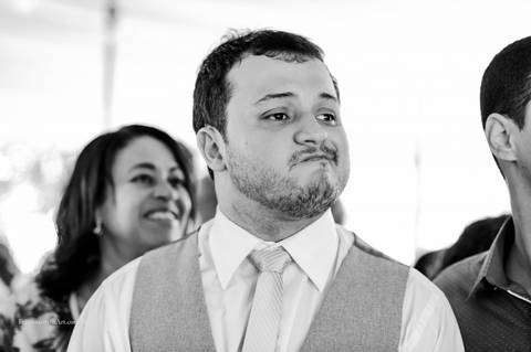 Fotografia espontânea com careta, noivo emocionado ao ver a noiva com vestido branco'