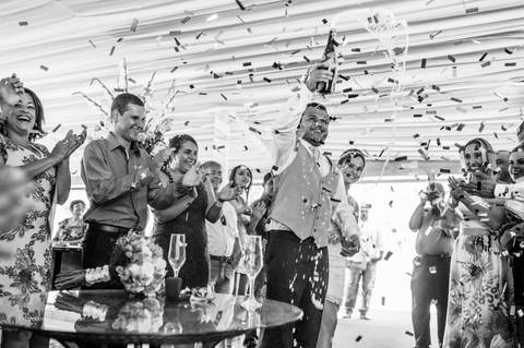 Comemoração do casamento, casamento a tarde, estourando champanhe no dia casamento, taças na mesa, fotografia de comemoração em preto e branco'