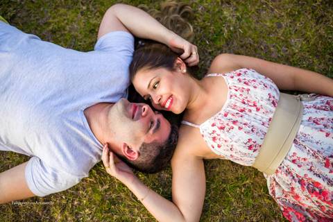 casal deitado na grama se amando, fotografia de primeiro olhar entre duas pessoas, pré casamento com amor, casal deitados namorando'