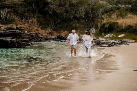Casal correndo e se  divertindo na praia '