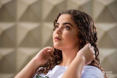 Fotografia de rosto, olho castanho claro, fotografia com as mãos no cabelo'