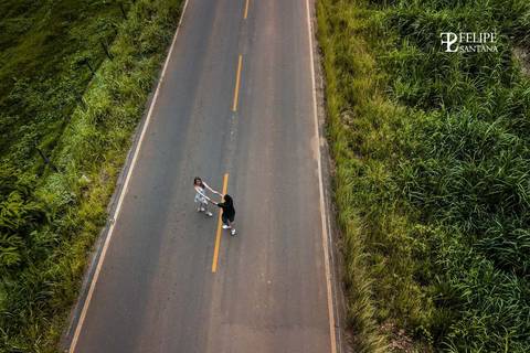 Ensaio de pré casamento com drone, fotografia do alto, casal se amando na estrada no pré casamento'
