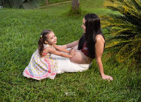 Foto de mãe e filha deitada na grama se divertindo '