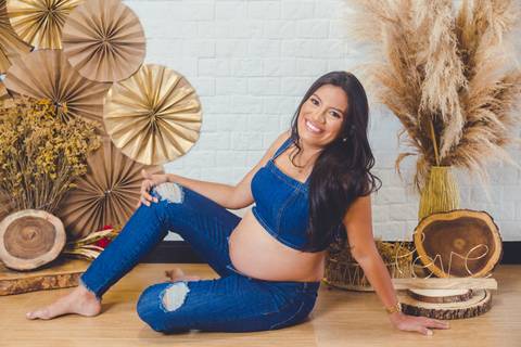 gravida deitada e sorrindo em book de fotos para gestante'